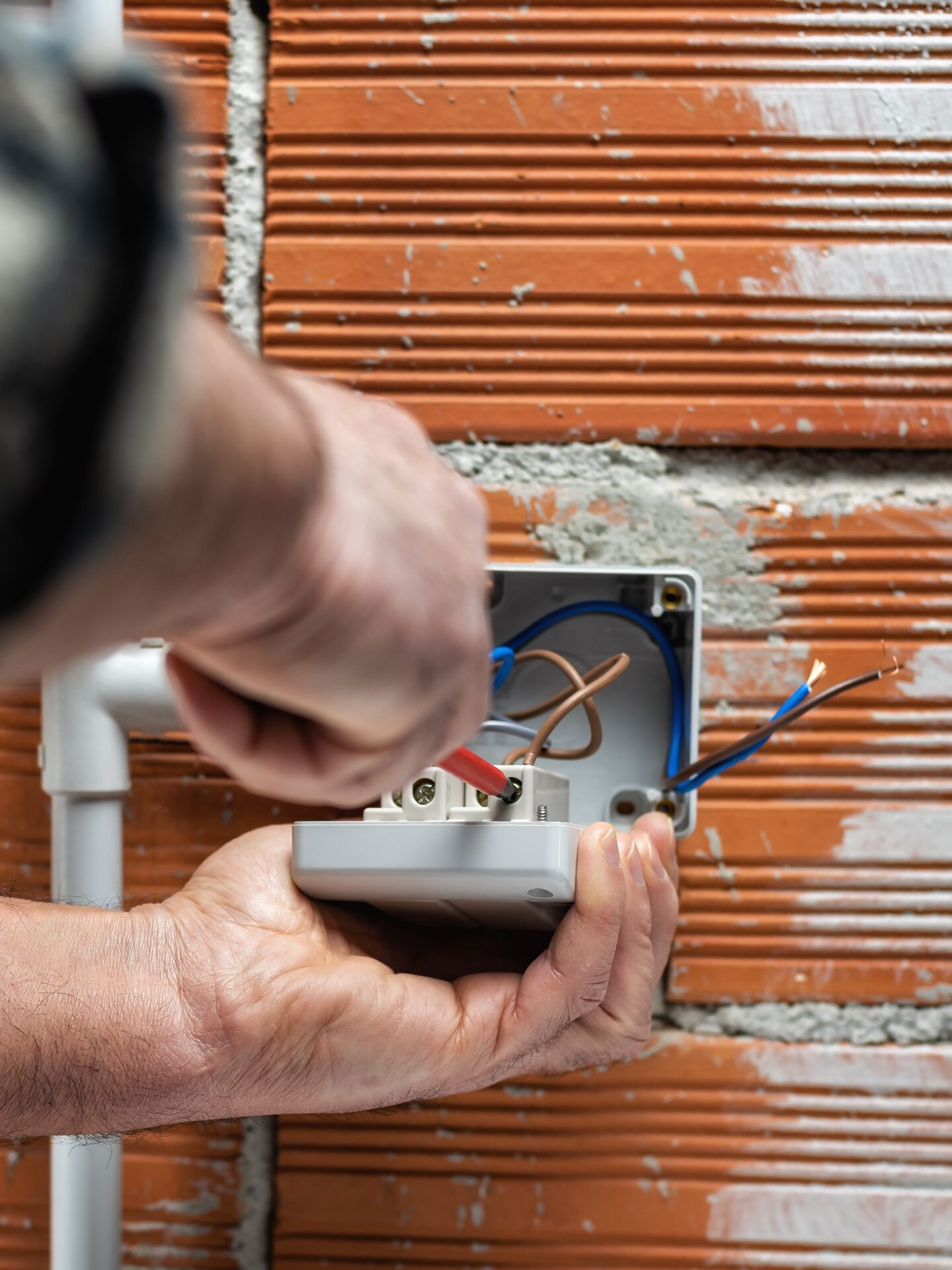 Electrician worker at work with a screwdriver fixes the cable in the terminal of the switch